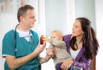 Obraz premium pediatric doctor giving pills bottle to mother with baby