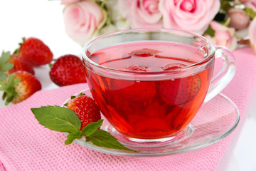 Delicious strawberry tea on table close-up