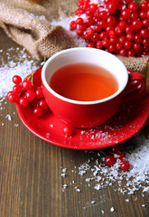 Still life with viburnum  tea in cup, berries and snow,
