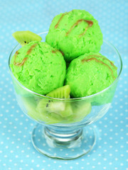 Delicious ice cream on glass vase on blue tablecloth