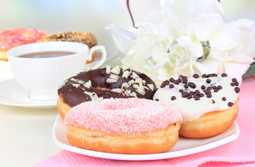 Sweet donuts with cup of tea on table close-up