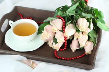 Beautiful bouquet of roses, on wooden tray, on light background