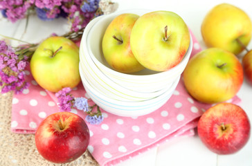 Juicy apples on plate on white wooden table