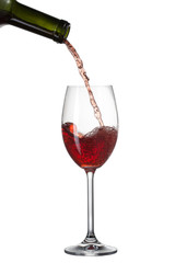 Red wine pouring into glass with splash isolated on white