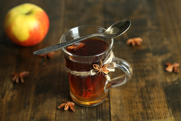 Hot beverage in glass cup with fruits and spices,