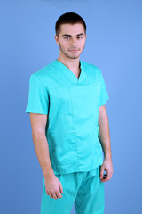 Fototapeta premium Young male doctor on blue background