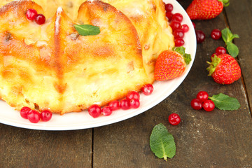 Tasty homemade cake with berries, on wooden table