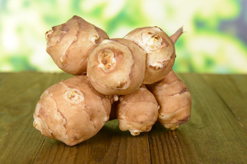Topinambur roots on table on bright background