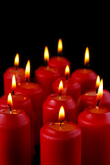 Burning red candles with black background