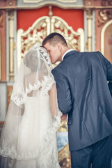 Fototapeta premium Married couple kissing in a church