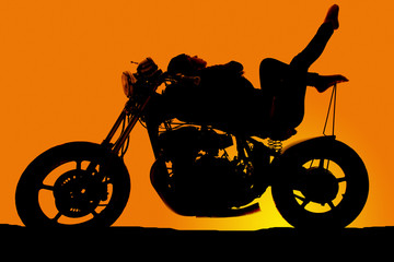 Fototapeta na wymiar Silhouette woman on motorcycle lay back toes up