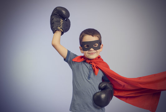Superhero kid wearing boxing gloves