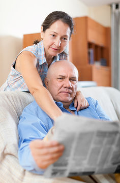 Happy couple of grandparents with newspaper