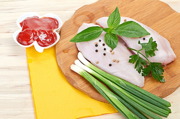 Raw chicken breasts on cutting board