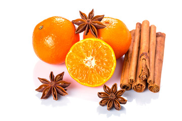 Orange fruit, cinnamon sticks and anise stars isolated on white