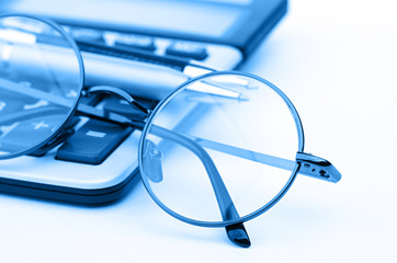 glasses and pen on calculator