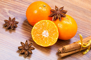 Obraz na płótnie Canvas Orange fruit, cinnamon sticks and anise stars on wooden table