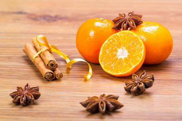 Orange fruit, cinnamon sticks and anise stars on wooden table