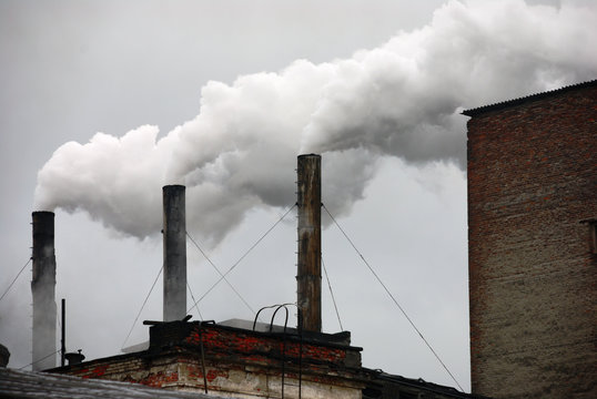 three smoking factory chimneys