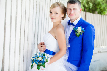 wedding pair at the wooden white fence