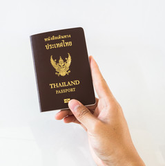Hand holding an Thailand passport