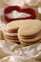 Red cookie cutter and a pile of gingerbread cookies