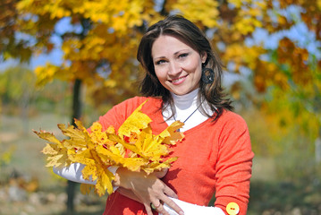 portrait of a beautiful girl among the yellow leaves in autumn