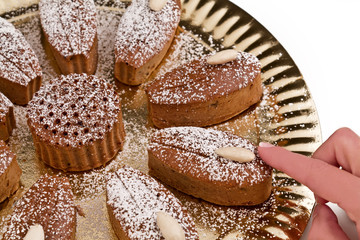 pastry chef is decorating delicious muffins with almonds