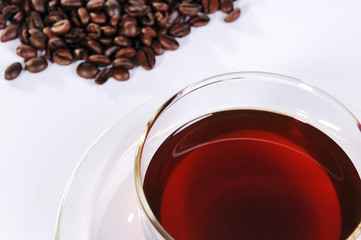 Kaffeetasse aus Glas mit Kaffeebohnen vor weißem Hintergrund