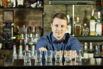 young man working as a bartender in a nightclub bar