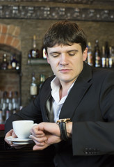 Young man drinking coffee in a bar