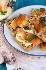 Salmon sandwiches on plate  on wooden table close-up