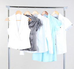 Office female clothes on hangers, on gray background