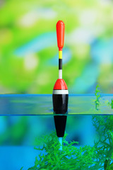 Fishing float in water on natural background