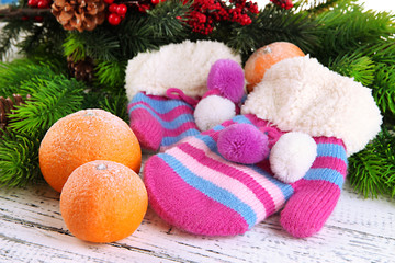 Striped mittens with fir branches and tangerines