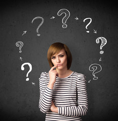 Young woman thinking with question mark circulation around her h