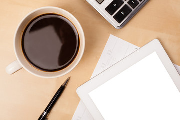 Tablet pc with empty space and a cup of coffee on a desk