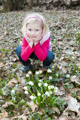 little girl with snowflakes in spring nature