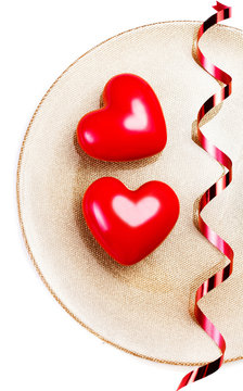 Two Red hearts on a golden plate isolated on white with festive