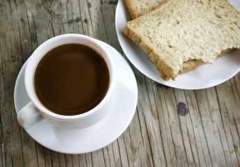 plate with a cup of coffee and bread