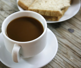 plate with a cup of coffee and bread
