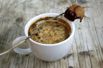 old coffee cup and dry rose on wooden