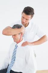 Male chiropractor doing neck adjustment