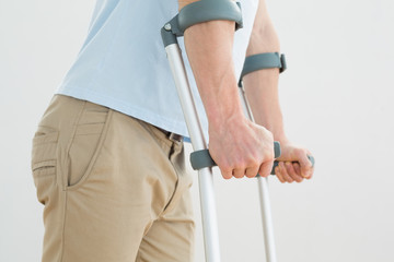 Close-up mid section of a man with crutches - Powered by Adobe