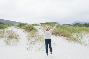 Senior woman jumping at the beach