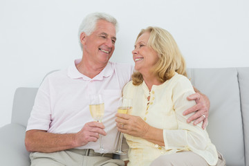Senior couple with champagne flutes at home