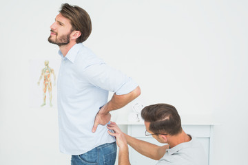 Obraz premium Male physiotherapist examining man's back