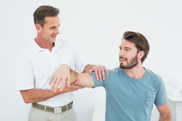 Obraz premium Male physiotherapist massaging a man's arm