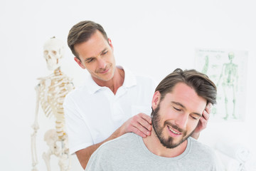 Obraz premium Male chiropractor doing neck adjustment