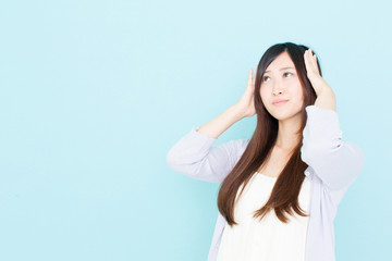 Fototapeta premium young asian woman thinking on blue background